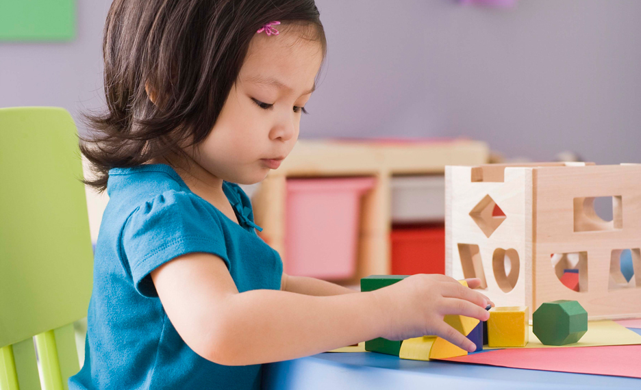Young child learning through play with wooden blocks