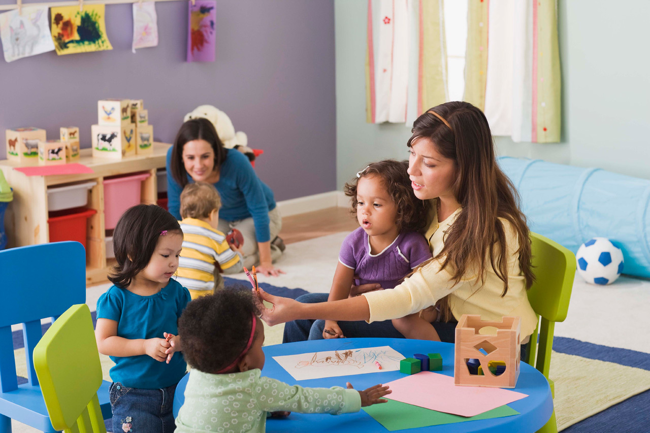 Teacher helping children learn together