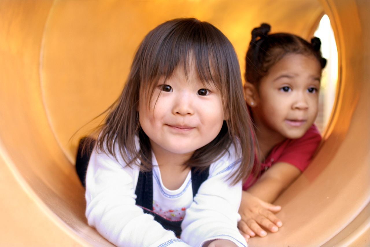 Young children playing together on a playground slide